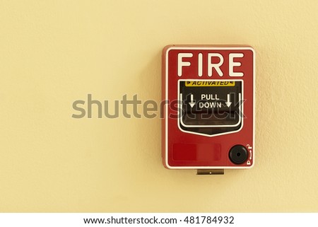 fire break glass alarm switch on the yellow wall