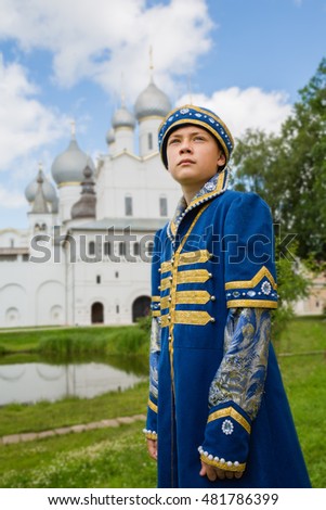 Boy in national russian suit Middle Ages on the background the Christian Cathedral in Kremlin Rostov Great (Veliky)