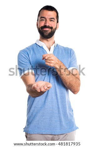 Man with blue shirt holding something