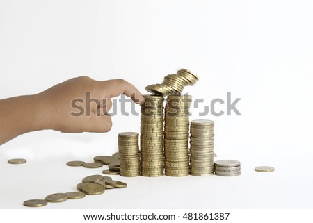 hand of a kid demolishing a pile of golden coins