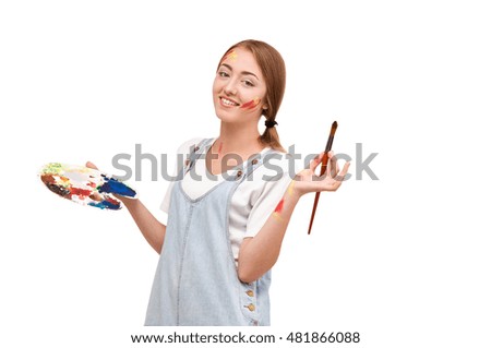 pretty young artist holding a palette and brushes. creation