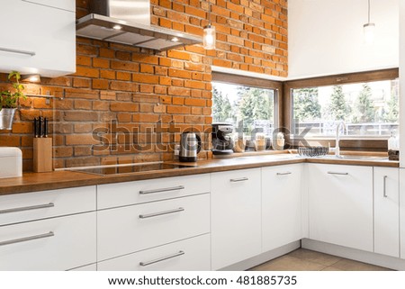 Picture of spacious kitchen with red brick wall