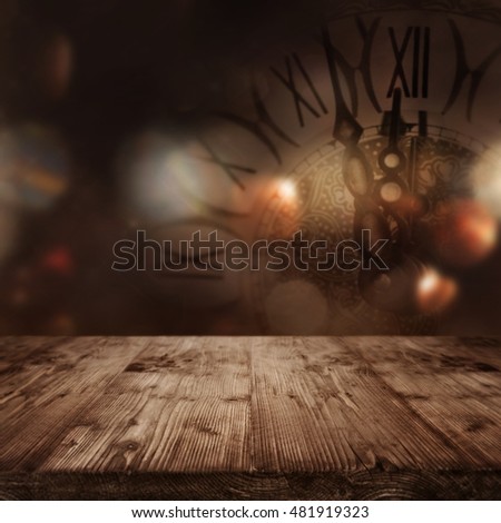 Wooden table in front of a festive background with a clock