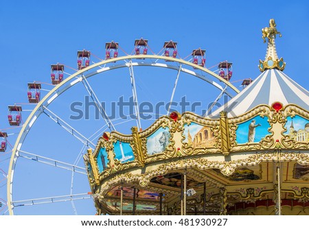 Carousel and ferris wheel in the park Royalty-Free Stock Photo #481930927
