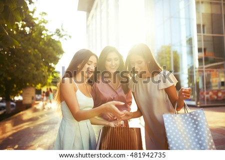 Beautiful girl with packages after shopping A picture of a group of happy friends shopping in the city.  Girl walking around the city after shopping. good mood. Evening light. shopping concept