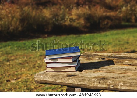 Pile of closed books on a table.