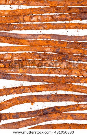 Vertical picture. Row of old rusty nails. On white background isolated. Spoiled iron with cork and metal chips. Decorative background.