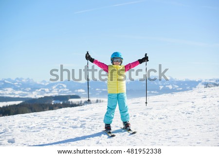 Smiling skier girl has fun on a sunny day in the mountains 