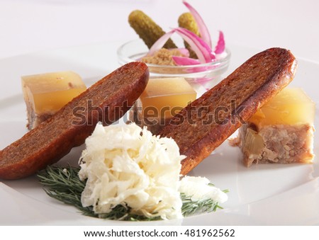 aspic with pickled cucumbers and croutons on plate