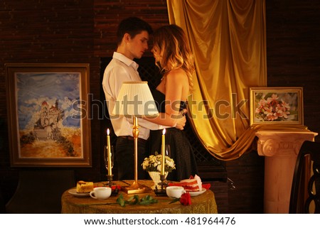 Couple in love dancing and kissing into luxary restaraunt. Romantic evening interior for loving couple.