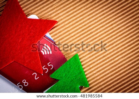 Credit card and felt christmas decoration on paper.