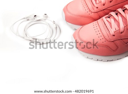 Sporting pink sneakers on a white background with headphones. Training. Sport