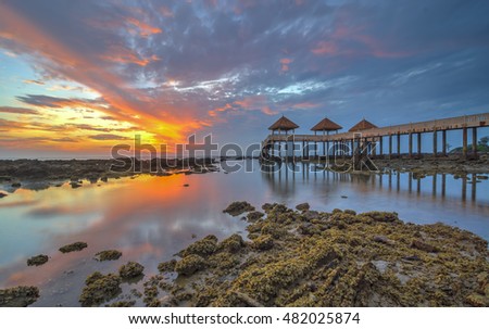 Beautiful long exposure sunrise shot at jetty. Image contain certain grain or noise and soft focus. Motion blur due long exposure shot and vibrant color.