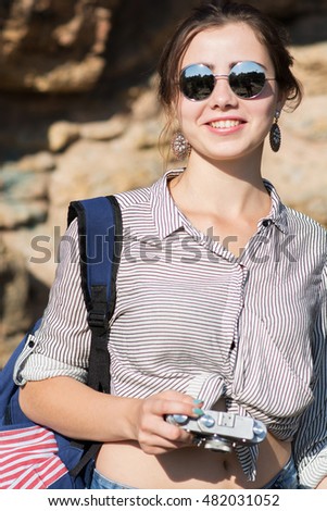 Young female traveller smiling with camera in hand