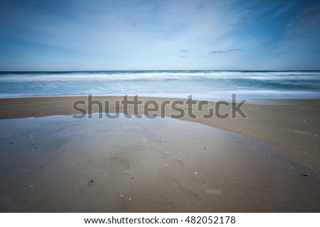 Stormy sea beach with slow shutter and waves flowing out.

