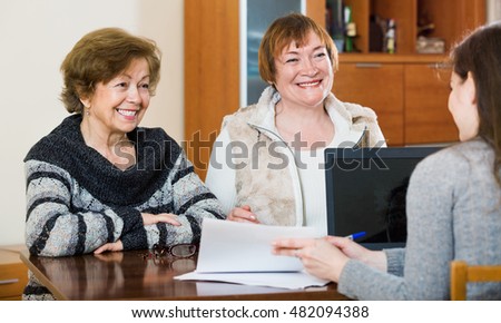 Senior positive women making will at public notary office and smiling