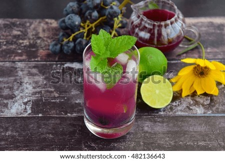 Grape mint lime soda mocktail with fresh grapes and lime at the background