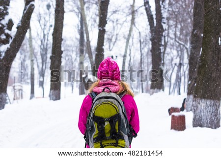 Young happy woman enjoy snow in winter city park outdoor
