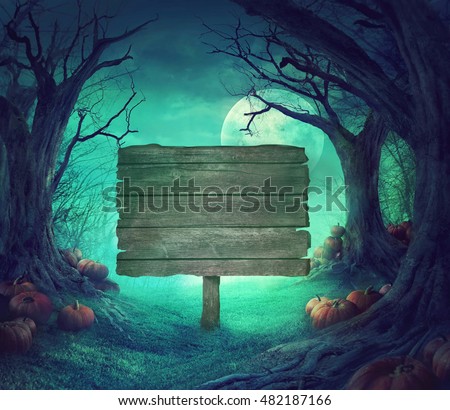 Halloween background. Spooky forest with dead trees and pumpkins.Halloween design with pumpkins. Wood sign
