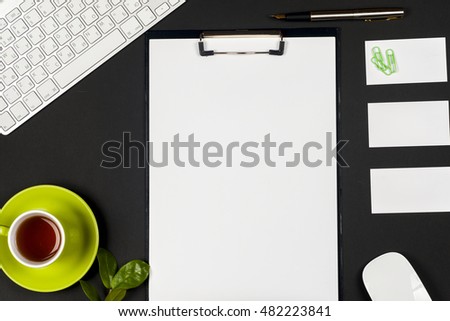 Office desk table with computer, business card blank, flower, coffee cup and pen. Top view with copy space. Corporate stationery branding mock-up