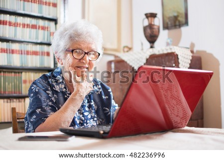 Surprised senior woman looking at laptop.