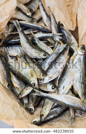 Salty dried fish on the brown paper. Stock-fish.