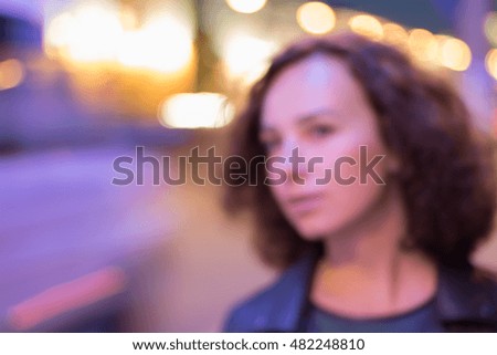 Defocused bokeh background. Night city road and woman. Blurred city lights.