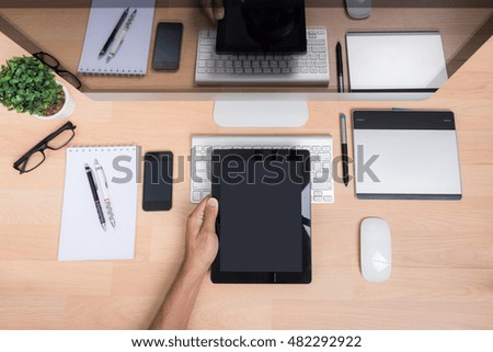 Top view office hand working with Tablet, mobile phone, keyboard mouse, computer PC, on wooden desk