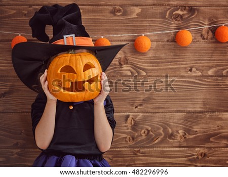 Happy Halloween! Cute little witch with a pumpkin.