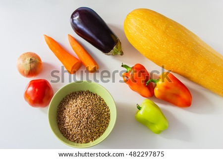 Colored foodstuffs  - vegetables and speltal on a white table.