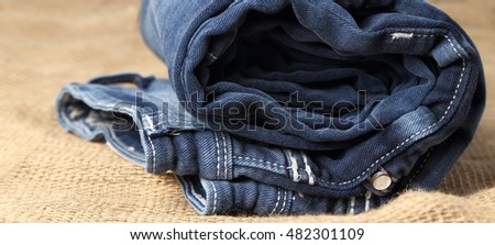 Old Blue jeans fashion design On brown hemp sack texture background,.Ripped jeans of a stack Hipster fashion copy space for text commentary .