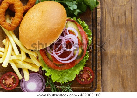 homemade hamburger with vegetables and a green salad