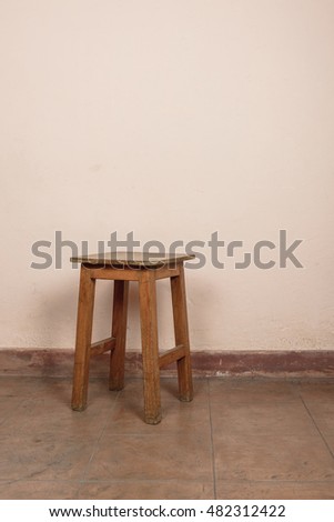 Rustic wooden stool, pink wall background