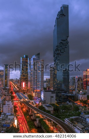 Night light of Bangkok. Traffic And sky train,  High rise building skyscraper commercial of future. Business concept of success industry tech architecture.