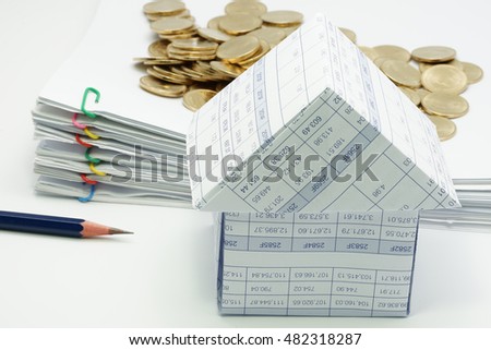 Close up house with pencil and pile of gold coins and pile overload document with colorful paperclip have blur on white background.