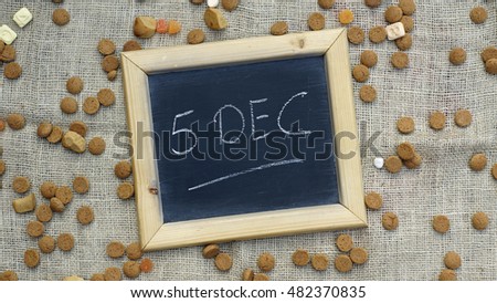 5th of December in Dutch written on a chalkboard between ginger nuts and candy's for the Dutch Santa-Claus                            