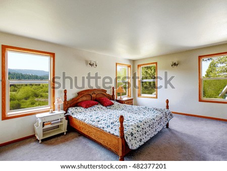 White bedroom interior with wooden carved bed and carpet floor. Northwest, USA