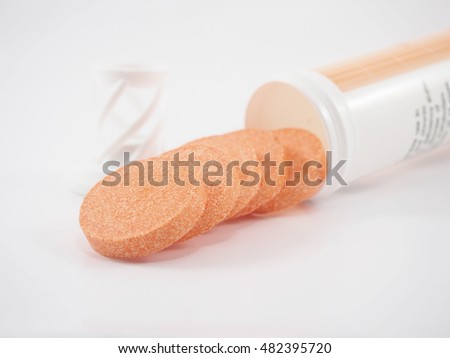Stack of vitamin mineral supplement effervescent tablets on white background.