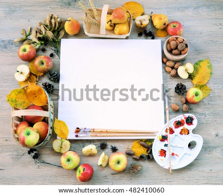 Autumn frame from fruits, leaves and cones and palette with paints on wooden ,nature background with copy place for text or logo