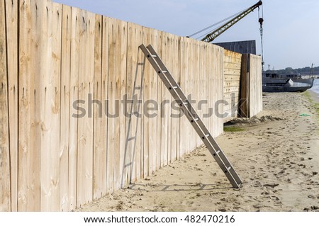 Wooden plank fence and the metal ladder.Seashore - Stock image.