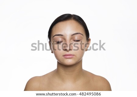 Close-up face portrait of young woman with my eyes closed without make-up against white background