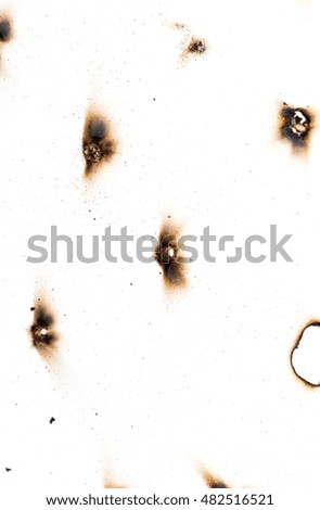 Collection of burnt holes in a piece of paper