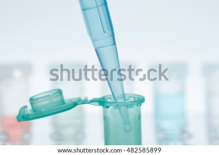 Still life of micropipette pipetting liquid into microcentrifuge tube