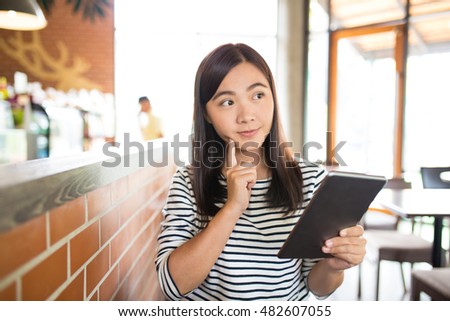 Woman typing tablet in cafe