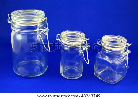 Empty small Jars. Picture of empty glass small size ingredient jars with different shapes with spring closure and rubber seal on blue background