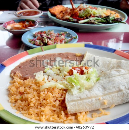 Table spread with tasty tacos,rice,beans, and salsa