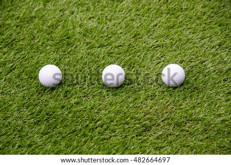 three golf ball on grass