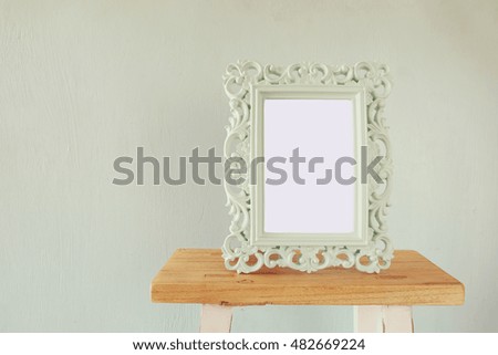 Image of vintage antique classical frame on wooden table. vintage filtered