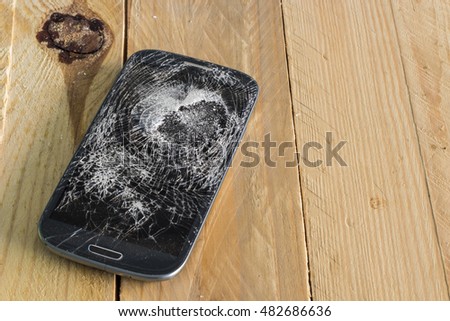 Broken glass of smart phone on the wood table