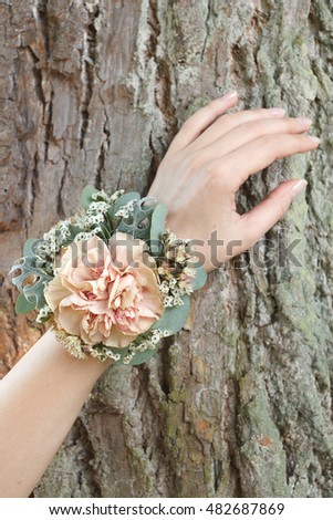 Dusty pink carnation wrist corsage on a hand